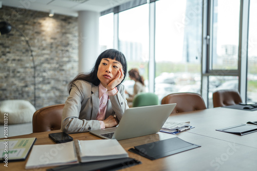 Obraz na plátne Asian businesswoman experiencing boredom and burnout during office work