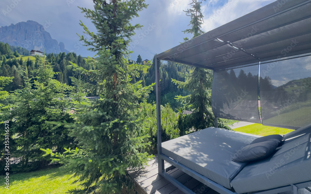 Obraz premium Modern patio furniture with sofa. Overlooks rich green mountain landscape. Sunny day bright airy atmosphere. Perfect outdoor living space