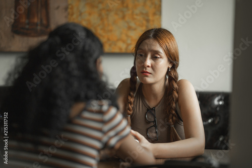 Cuadro en lienzo Two young women having a serious conversation in a cafe