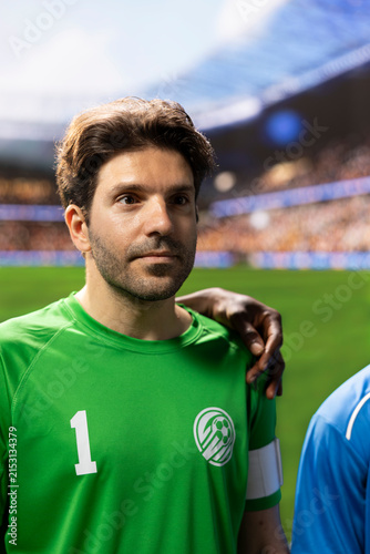 Принти на полотні Goalkeeper in a green jersey and captain armband stands shoulder to shoulder with teammates in the pre-match national anthem ceremony ahead of kickoff