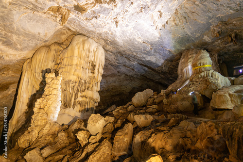 Foto Wide view of large lit stalactites and stalagmites inside a spacious underground