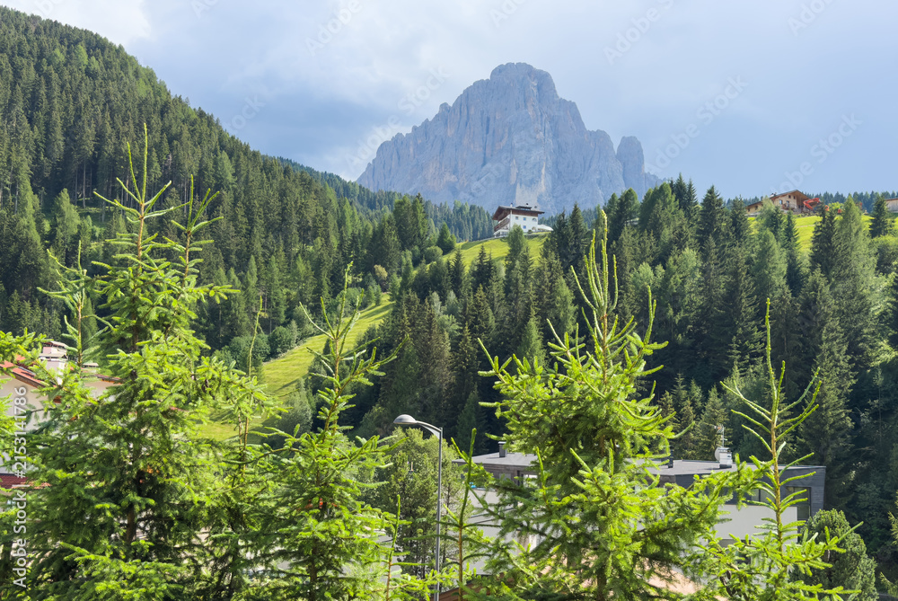 Obraz premium View of beautiful landscape in the Alps with fresh green meadows and mountain tops in the background on a sunny day with blue sky and clouds in summertime. Alpe di Cisles, Seceda Ridgeline, Dolomiti ,