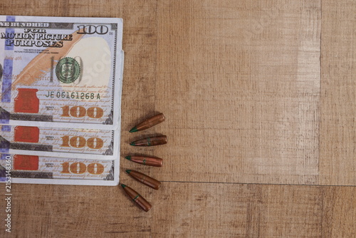 Copy Space with Rifle Bullets Beside Stacked US Dollars