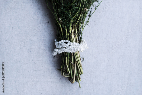 Fresh dill bundle decorated with white pearl beads