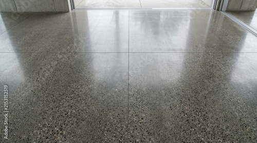 Polished concrete floor with reflective surface and stone texture.