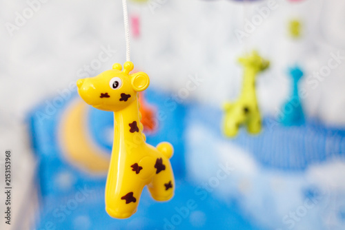 A close-up of a cute yellow plastic giraffe toy