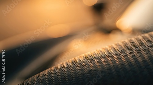 Close-up Abstract Texture of Woven Material with Golden Bokeh Background