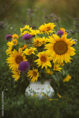 Still-life. A photograph of a bouquet of sunflowers with thistles.