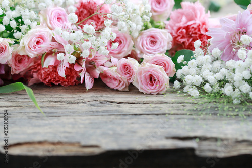 Принти на полотні Floral background with pink roses, carnations, chrysanthemums and gypsophila paniculata on wooden background, copy space