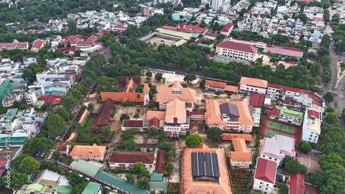 Cinematic FPV drone footage flying from behind Mang Lang Church and passing closely between its distinctive twin bell towers in Phu Yen, Vietnam. The immersive flight path highlights the historic