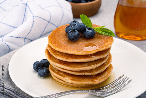 Stack of Fluffy Pancakes Topped with Fresh Blueberries and Drizzled with Honey	