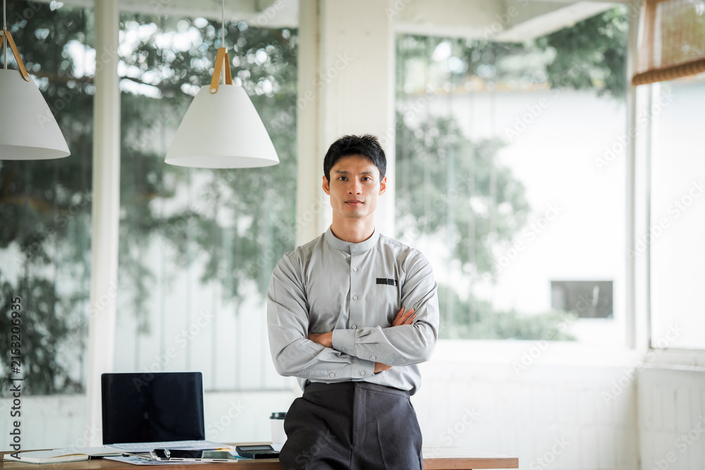 Fototapeta premium Smiling Asian businessman using a digital tablet and stylus in a modern office, representing digital work, technology, communication, productivity, and professional business.