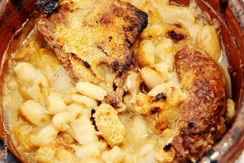 Traditional Toulouse cassoulet close-up with tender duck meat, pork sausage and white beans, slow-cooked French comfort food with golden bread crumbs, rustic texture and appetizing detail