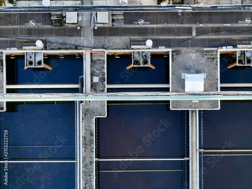 Aerial view of the water treatment facility with rectangular sedimentation tanks, industrial pipes, and concrete walkways in Tampere, Pirkanmaa, Finland.