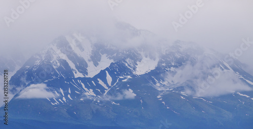 Mountain landscape, snowy peaks in the clouds