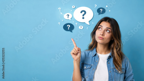Young woman points upward while looking thoughtful with question mark speech bubbles on a blue background