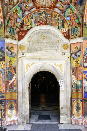 Obraz na plátne The entrance to the Rila Monastery in Bulgaria, adorned with vibrant frescoes depicting religious scenes and figures, including angels and saints