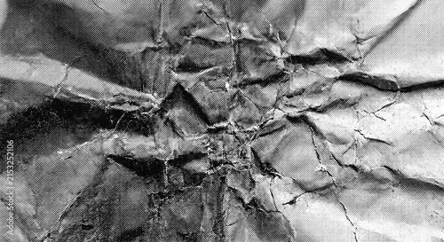 High-resolution professional stock photo of monochrome crumpled paper texture with vintage halftone dot print pattern.