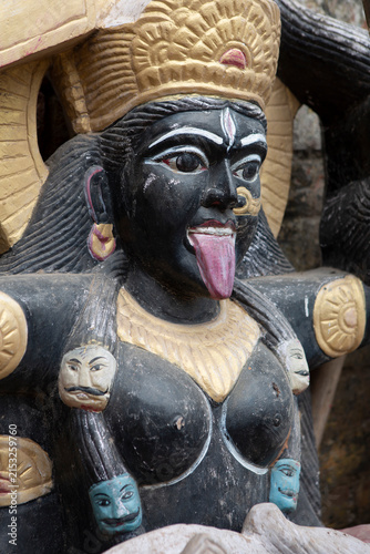 Statue of goddess Kali with painted skulls and protruding tongue in India
