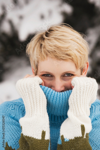 Italy, South Tyrol, Young woman, covering face with turtleneck pullover, portrait, close-up
