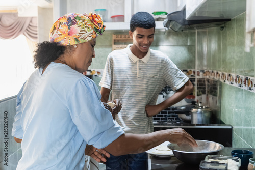 Grandmother and grandson cooking together in kitchen