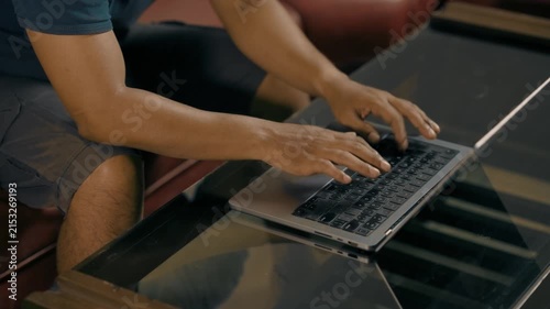 Close-up of asian male hands typing on laptop computer keyboard, working searching for information and doing marketing data research or communicating with clients.