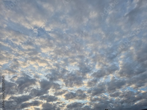 Foto Glimmer of sunlight bouncing off altocumulus clouds in the sky