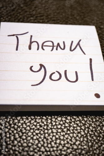 A handwritten note with the text Thank You  on it.