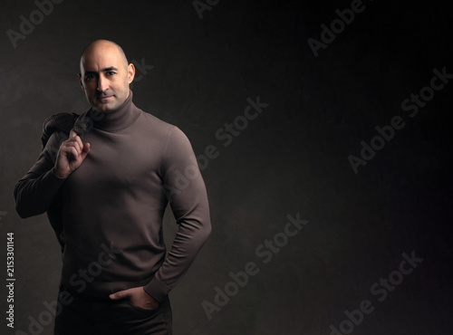 Smiling middle aged man holding blazer jacket over shoulder with copy space