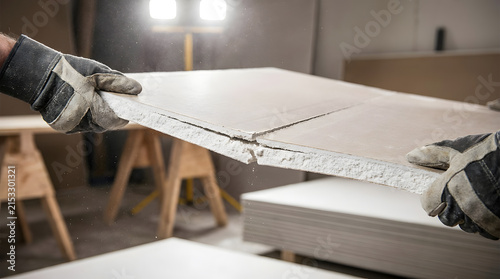 Cutting and snapping drywall panels for home renovation | Professional contractor installing plasterboard | DIY drywall installation techniques | Scoring and snapping gypsum board