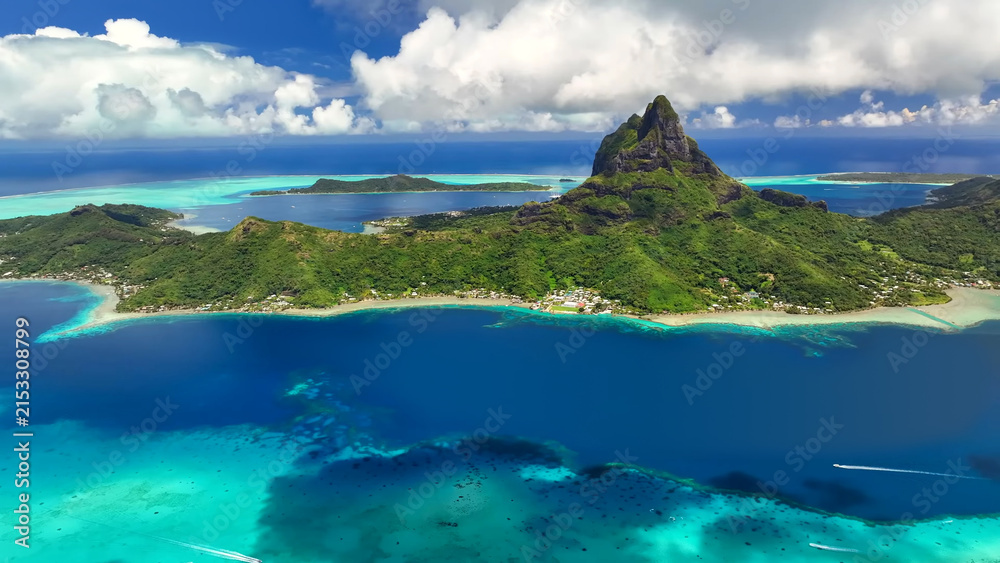 Fototapeta premium Luxury resort photo of French Polynesia tropical paradise island Bora Bora in Pacific Ocean. Beautiful photography with sandy beach, palm trees, coral reef, azure ocean, sky with clouds on horizon. 
