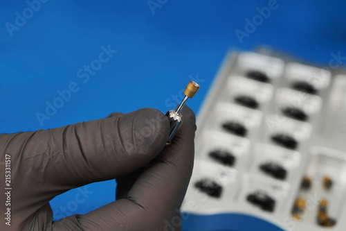 a dental instrument for working with a dental implant, which the doctor holds in a glove.