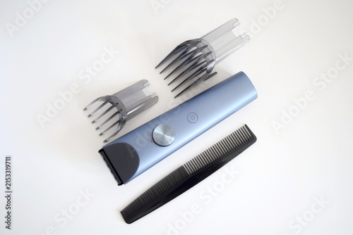 Electric hair clipper set with comb attachments and barber comb on white background 