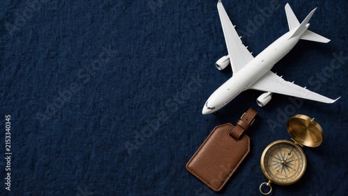 Airplane Model and Travel Accessories on Dark Blue Textured Surface.