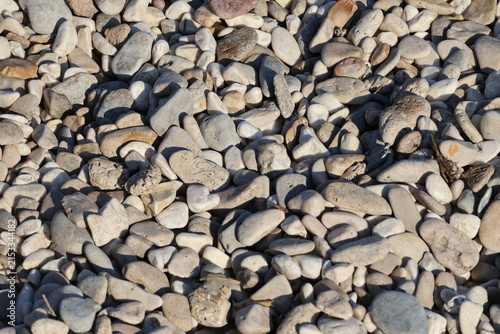 Photography Close-up of smooth light-colored sea pebbles under harsh sunlight
