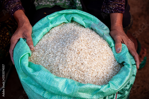 DON DET, LAOS – Hands hold a cloth bag filled with white rice at a local market on Don Det, where this staple grain forms the foundation of daily life in rural Laos.