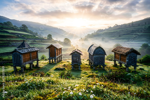 Traditional stone granaries in misty mountain valley at sunrise