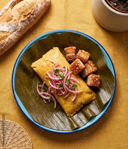 Konstfotografi Traditional Tamale on Banana Leaf Topped with Pickled Onions and Crispy Chicharr