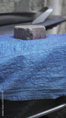 Brick Used as Weight on Blue Protective Tarp for Maintenance and Repair