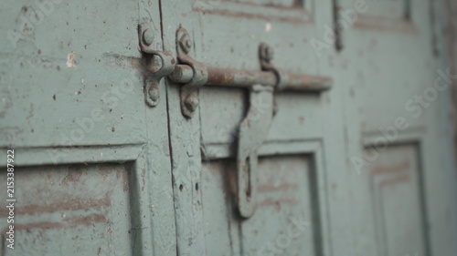 Weathered Green Metal Door with Rusty Sliding Bolt and Industrial Hardware