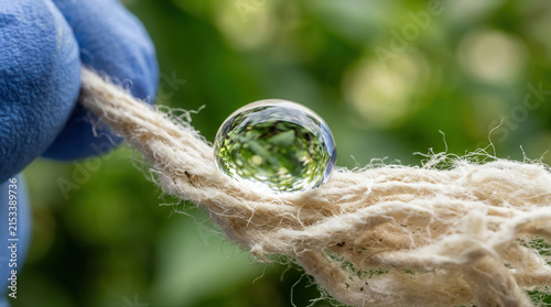 Detailed view of a water droplet resting on natural fiber symbolizing eco friendly cotton cultivation methods