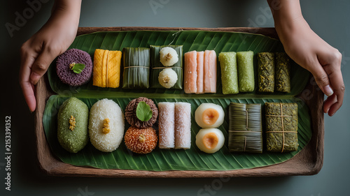 Top View Of Person Holding Wooden Tray With Assorted Traditional Southeast Asian Steamed Rice Cakes