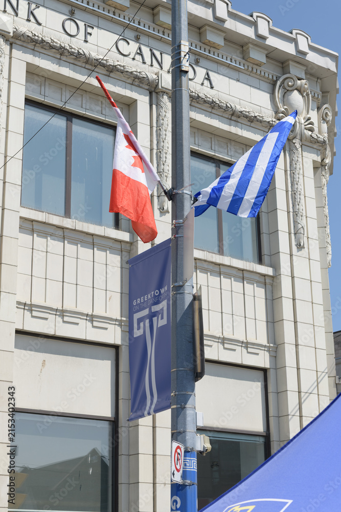 Fototapeta premium flags of Canada and Greece with banner in Greek Town near RBC Royal Bank 650 Danforth Av, Toronto