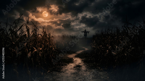 A dark and eerie path winds through a cornfield under the glow of a full moon with a shadowy scarecrow silhouette