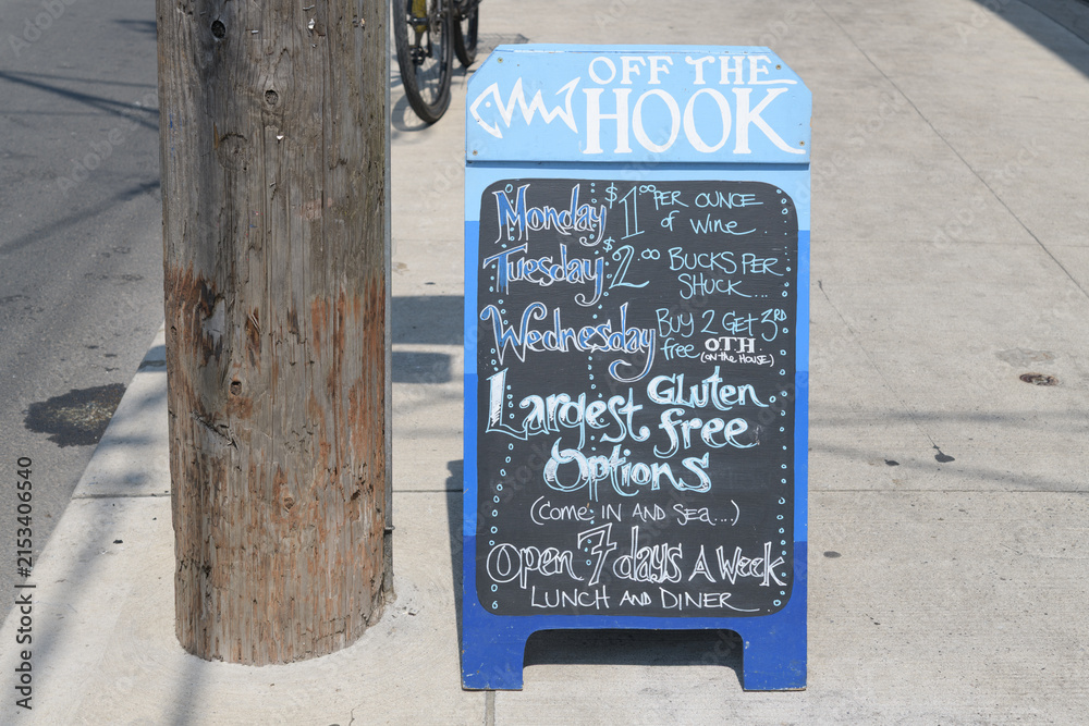 Fototapeta premium chalkboard sidewalk sign outside Off The Hook Fishbar, a fish & chips restaurant, located at 749 Broadview AV, Toronto