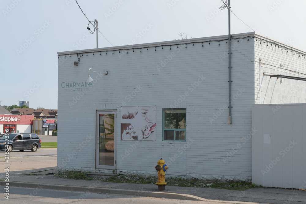 Fototapeta premium ghost sign on the exterior of Charmaine Sweets in its former location, an “iconic white brick building” at 115 Vanderhoof Av, East York, Toronto