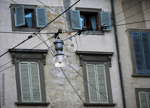 Vintage street lamp and shutters on weathered facade in Bergamo, Italy
