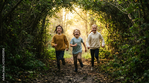 Three children running through a sunlit forest trail archway