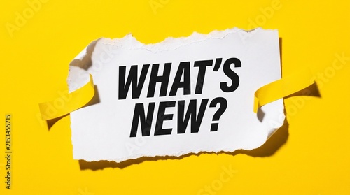 Fotografie Torn paper with ribbon showing what's new announcement on bright yellow backgrou