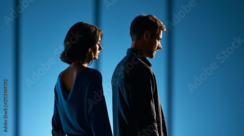Silhouette of a faceless couple with backs turned, relationship distance, emotional tension, communication breakdown, personal reflection, with copy space